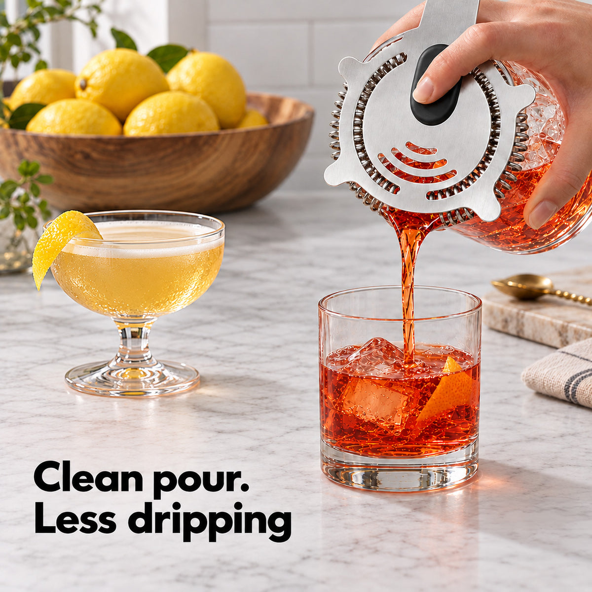 Pouring a Negroni through the Hawthorne strainer into a rocks glass for a clean pour
