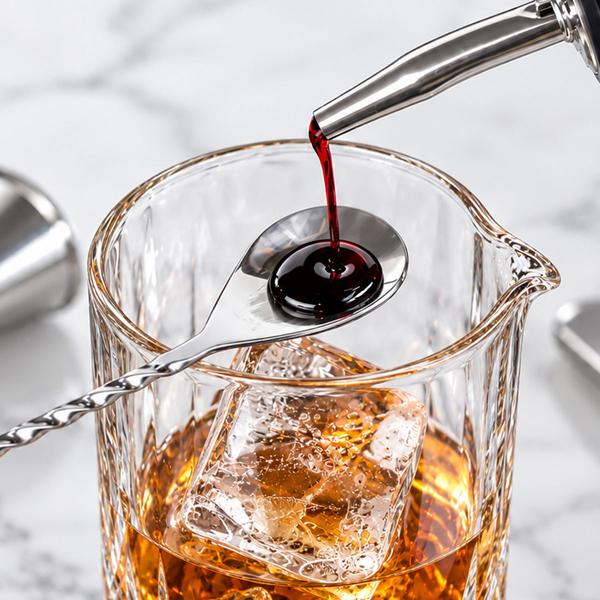 Layering a ruby syrup over the back of the bar spoon into a mixing glass