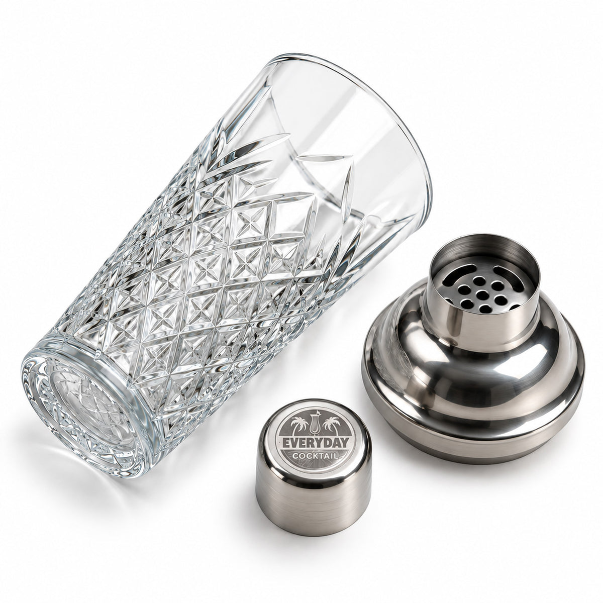 The three parts of the crystal shaker: deep cut glass, steel strainer lid, engraved Everyday Cocktail cap