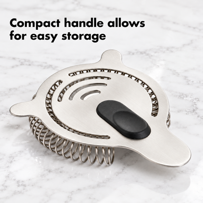 Hawthorne strainer with compact handle for easy storage on a marble counter