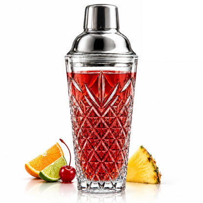 Deep cut crystal cocktail shaker with a red drink, orange, lime, cherry and pineapple