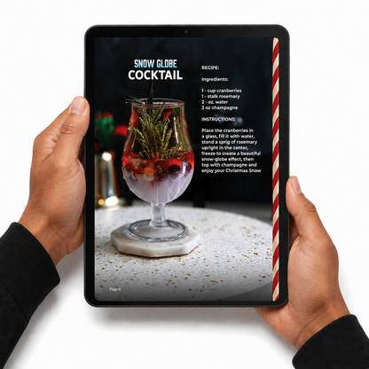Hands holding a tablet with the Snow Globe Cocktail recipe from Top 40 Christmas Cocktails 